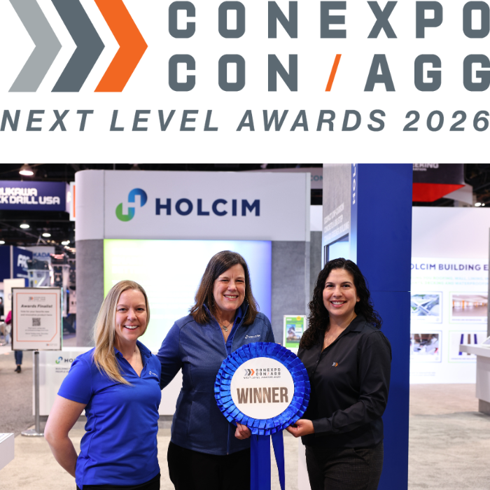 Two women accepting a ribbon award for Next Level Awards from CONEXPO-CON/AGG