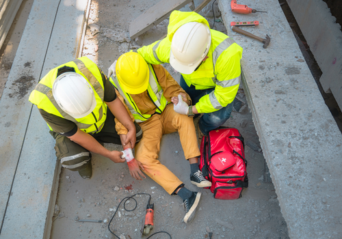 Safety team help a construction worker who has an accident.